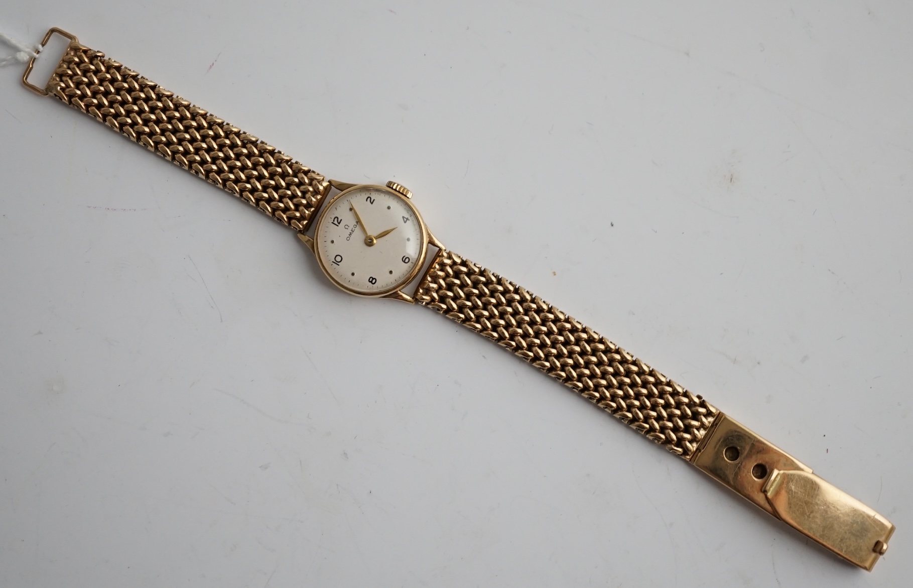 A lady's 9ct gold Omega manual wind wrist watch, on an associated 9ct bracelet, with Arabic and dot numerals, case diameter 20mm, overall length 16.7cm, gross weight 30 grams., no box or papers, with spare bracelet parts